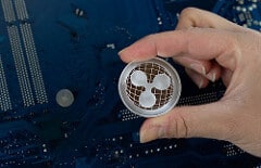 Hand holding silver Ripple XRP coin by wuestenigel XRP Ripple photo