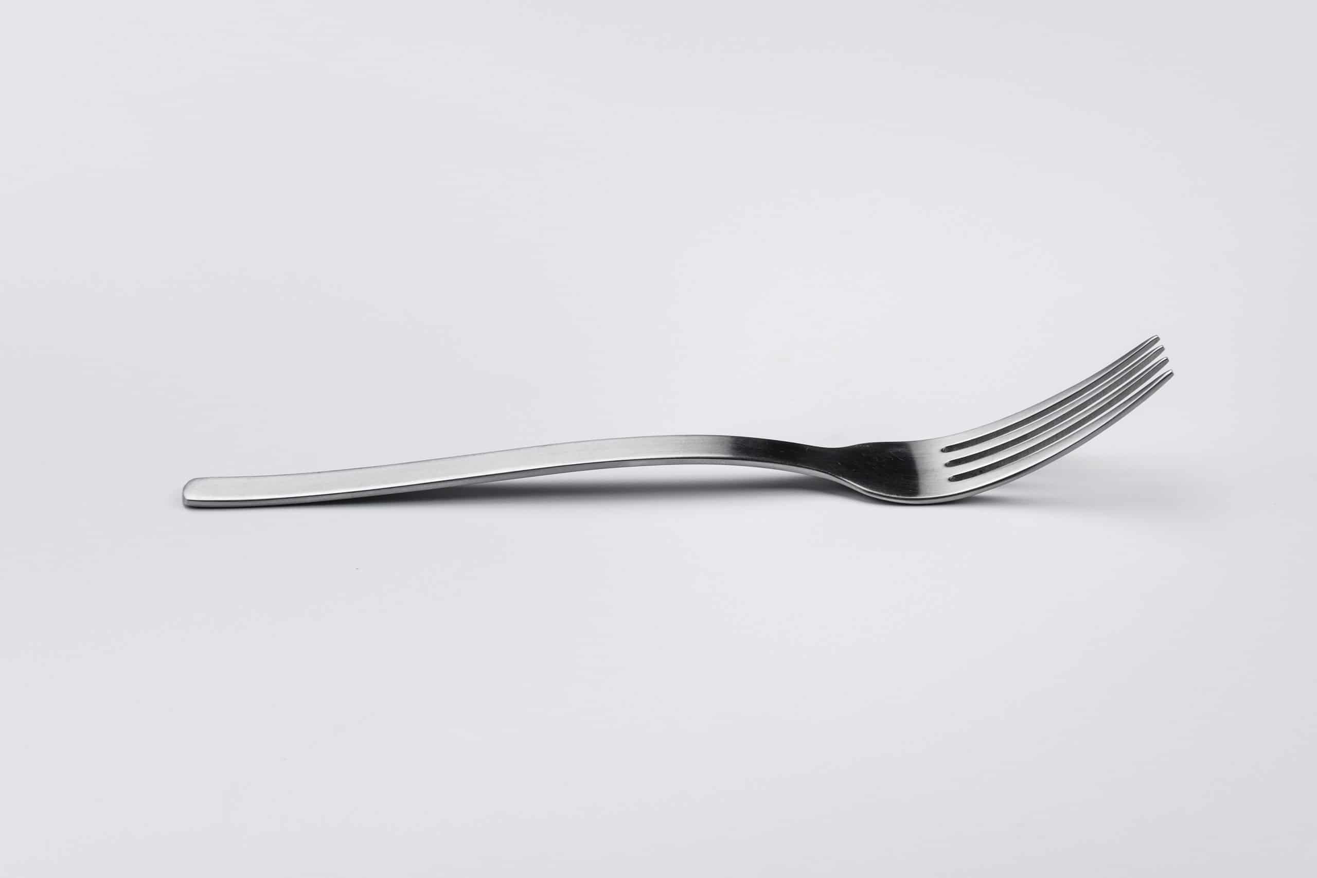 stainless steel fork on white surface