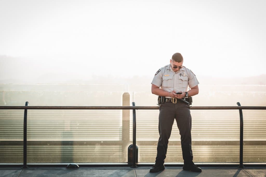 cop leaning on metal rail during a sunny day