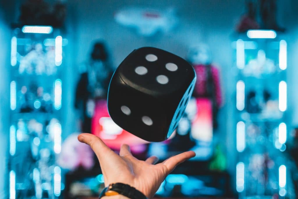 person's left palm about to catch black dice