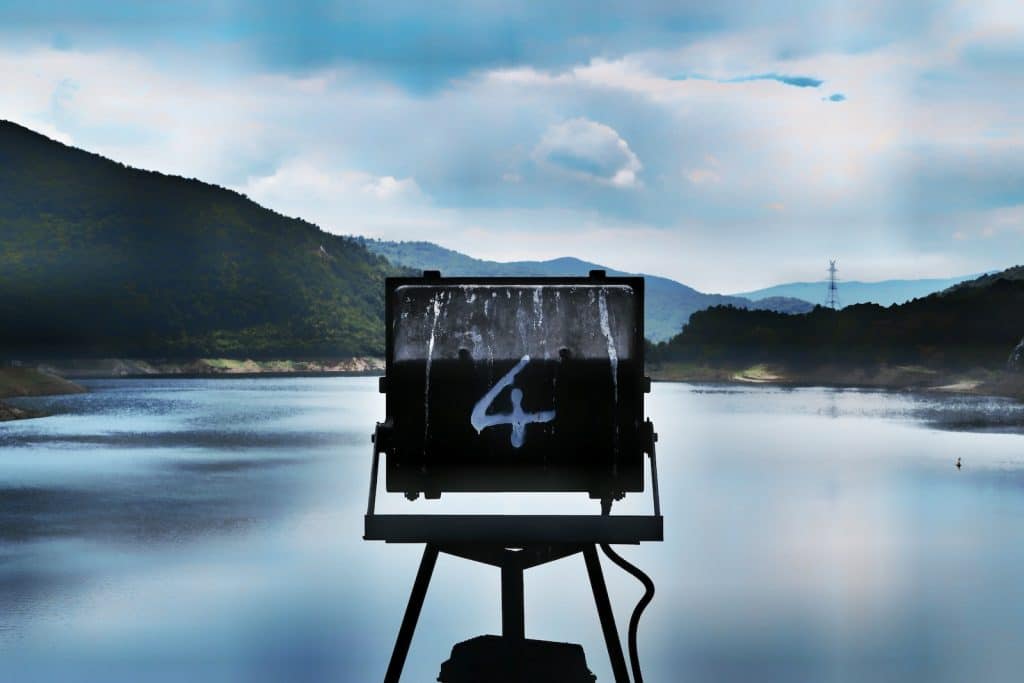 A sign marked with the number four over a lake