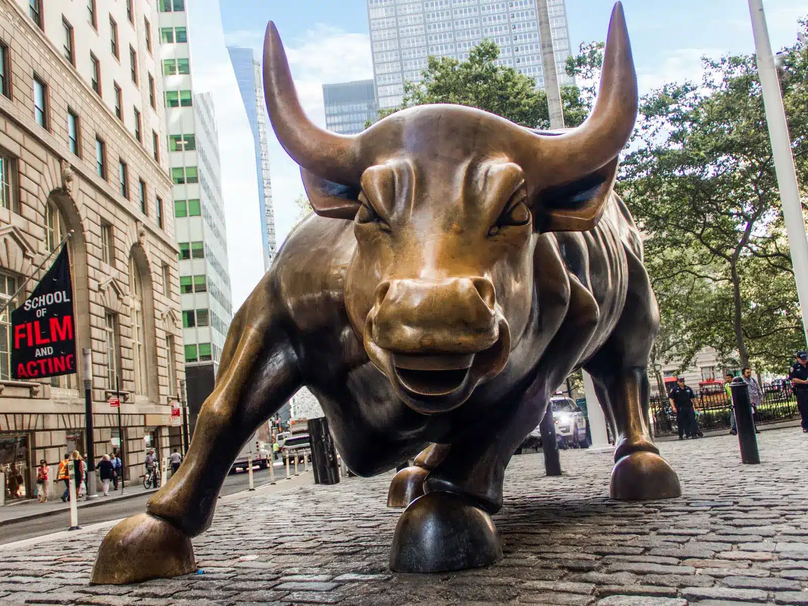 Wall Street Bull Statue Financial Market Inline Close-up view of the Charging Bull bronze statue on a cobblestone street in New York City